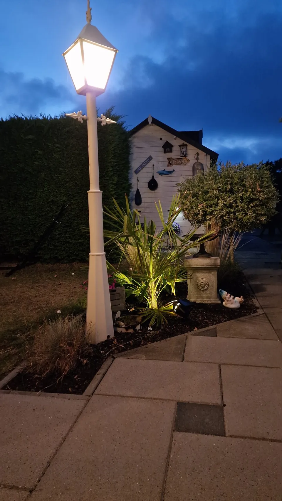 Gartenlaterne und Gartenhaus am Abend