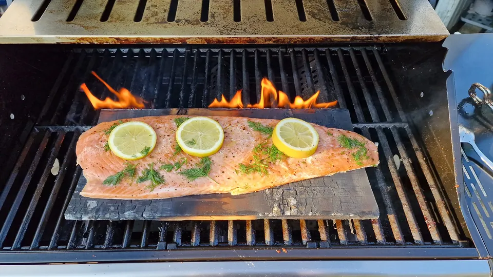 Lachs auf Zedernholz auf dem Gasgrill des Chalets