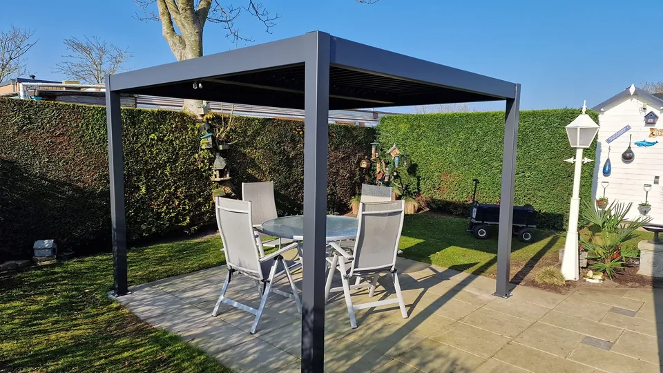 Sonnige Terrasse mit Lamellen-Pergola und Rasen