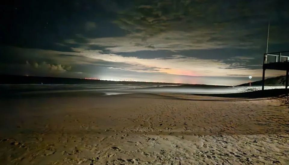 Nächtlicher Strand unter Wolkenhimmel