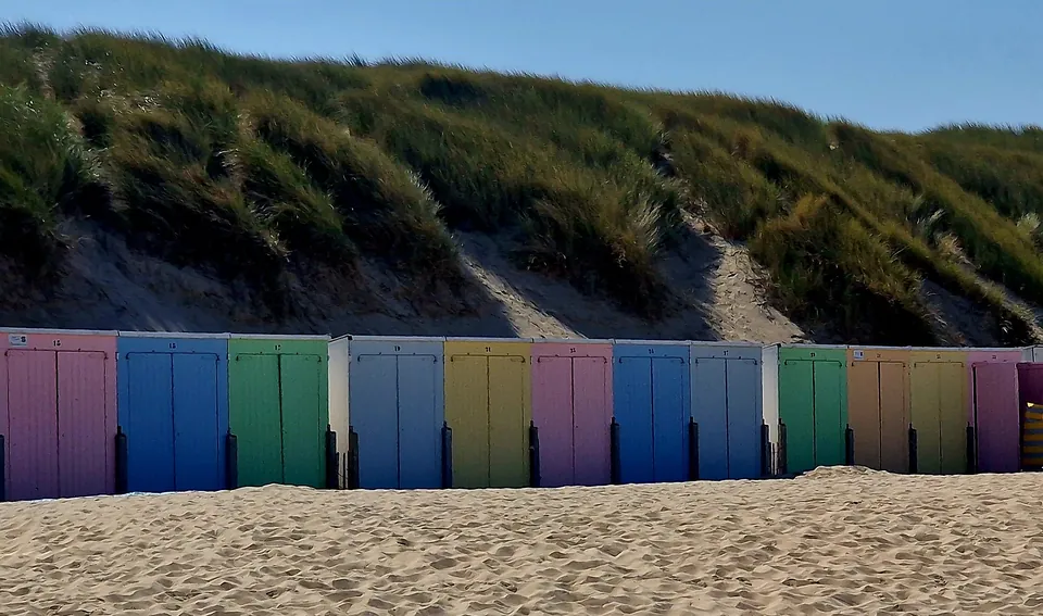 Bunte Strandhäuschen vor der Düne